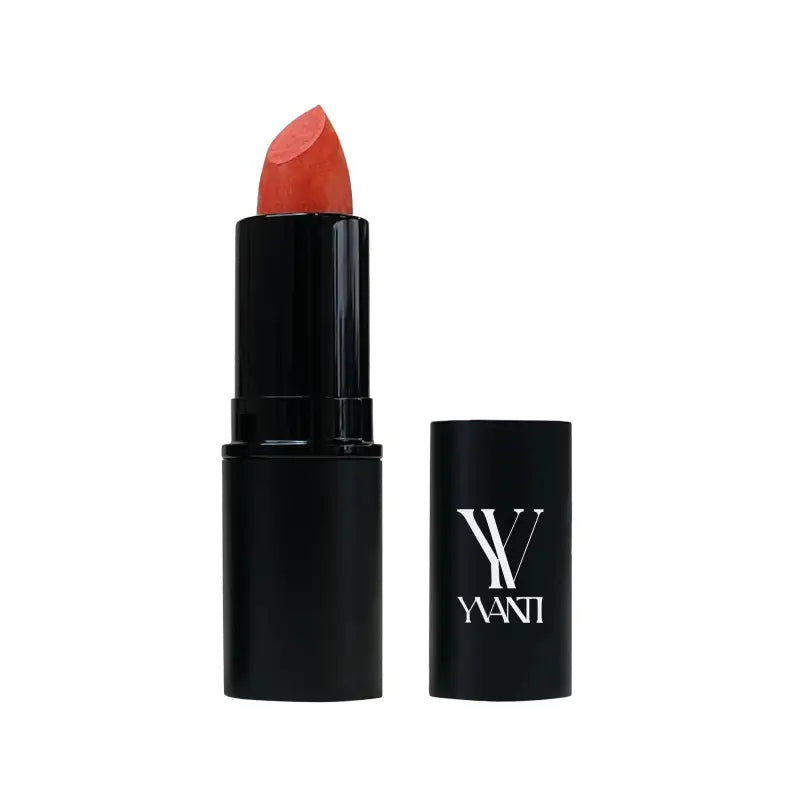 Coral-colored lipstick in black tube labeled WANT with jojoba esters for smooth application